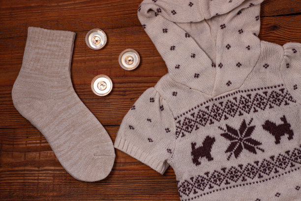 舒适的flatlay。冬天的概念。平铺的针织毛衣，蜡烛，针和纱线在木制的背景。温暖的周末。图片下载