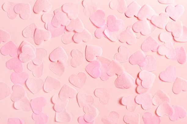 粉红色的心形纸在粉红色的背景，俯视图图片下载