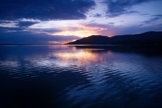 危地马拉，佩滕，伊察湖，紫色的天空上，橙色的日落伴随着戏剧性的波浪图片下载