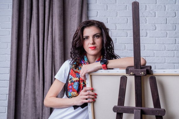 女艺术家在她的画室的帆布上作画图片下载