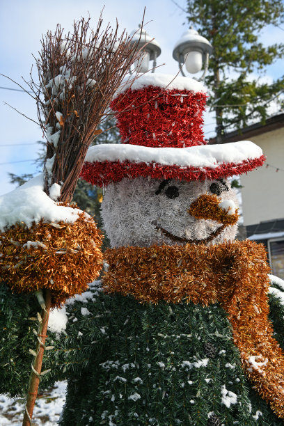 雪人装饰华丽。戴着帽子、扫帚和围巾的雪人。图片下载