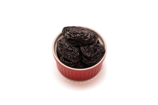 白底红碗里的梅子或干梅子。天然健康的甜食概念。特写,俯视图。本空间图片下载