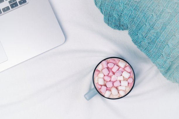 办公室的工作空间，一杯咖啡，笔记本电脑，在白色的背景编织毯子。平躺，俯视图图片下载