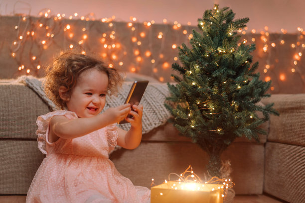 一个小女孩开心地用智能手机拍了一张新年礼物的照片图片下载