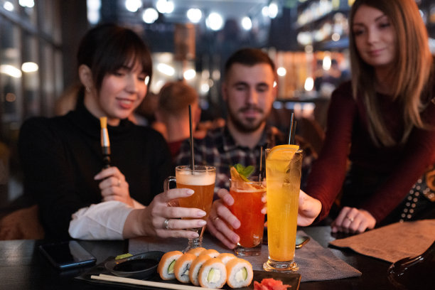 年轻的潮人在鸡尾酒会上拿着美味多彩的饮料。图片下载