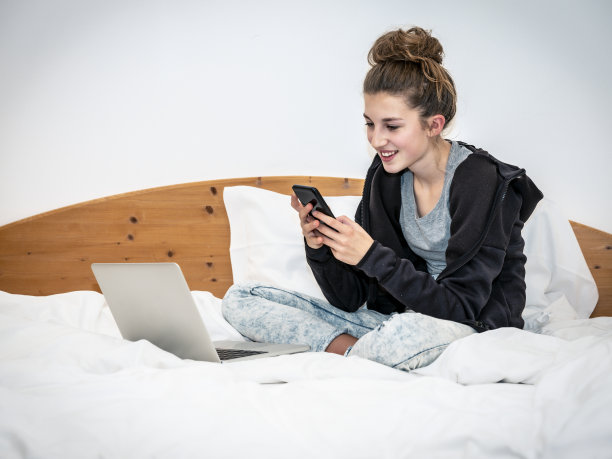 女孩在床上玩手机图片下载