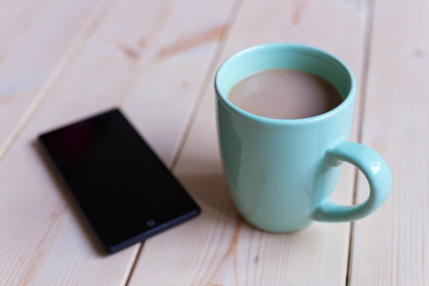 杯子与咖啡，茶和电话在木制表面，近距离。早上好!图片下载