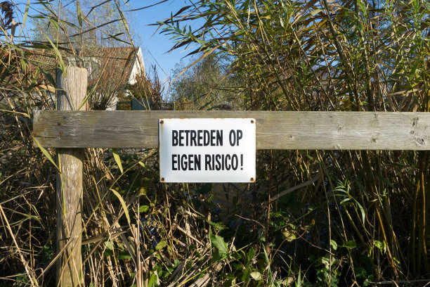 白色搪瓷板上黑字铭文“进入自行风险”。图片下载