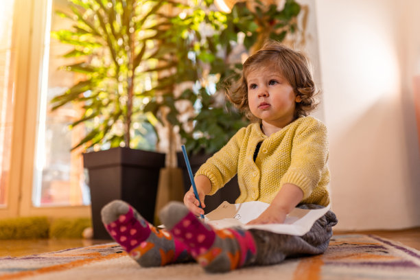 年轻女孩在地板上画画图片下载