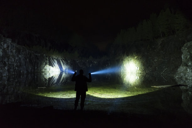 雨雾之夜，一个人站在户外，用手电筒照着图片下载