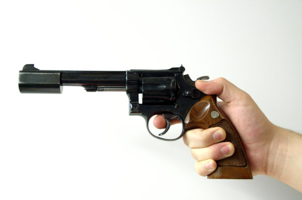 手持左轮手枪瞄准在光线背景下射击图片下载