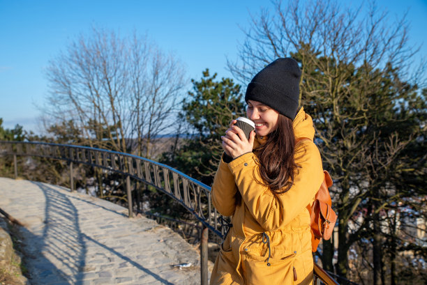 年轻漂亮的女人在室外的复印空间喝咖啡图片下载