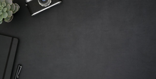 顶视图黑暗的现代工作场所与办公用品和复印空间在黑色的桌子上图片下载