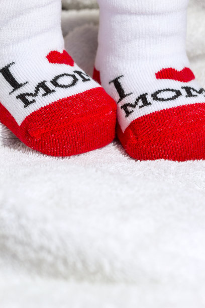 红色和白色的婴儿袜在白色的毯子上图片下载