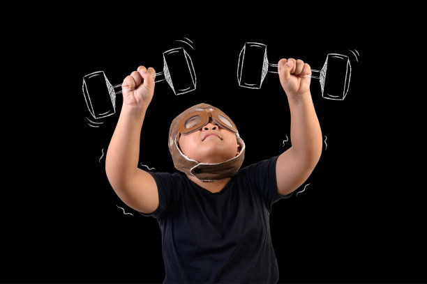 男孩假装自己是超级英雄，通过举重锻炼。画的概念。图片下载