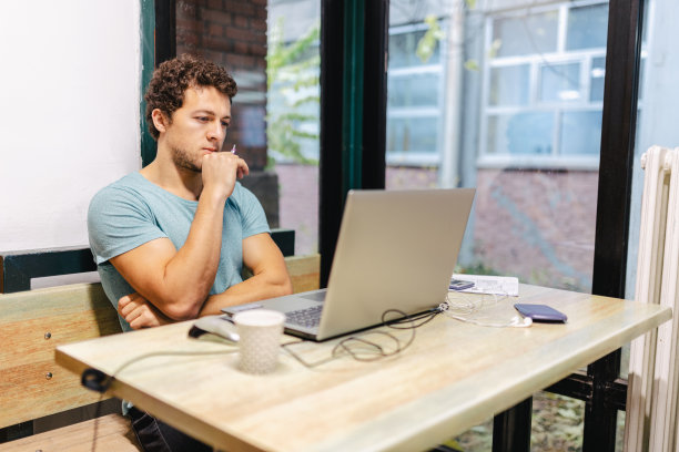 严肃的混血儿男学生严肃的脸坐在甲板上代替学习和使用笔记本电脑为学校项目素材图片
