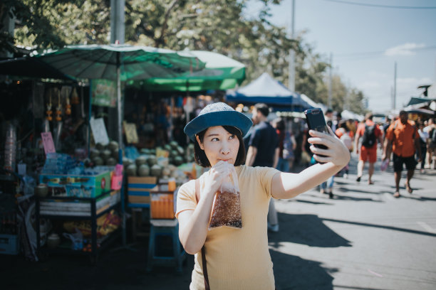 美丽的亚洲女人喜欢在Chatuchak周末市场喝可乐图片下载