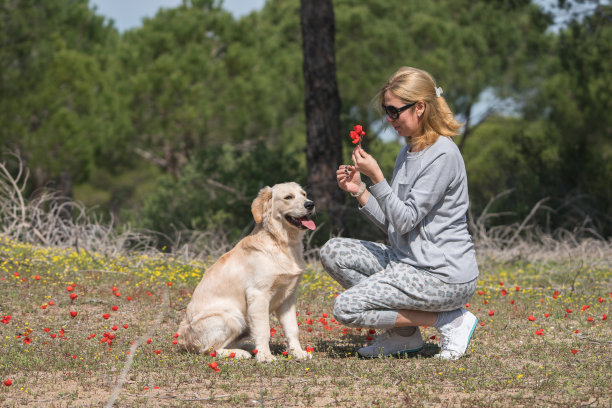 快乐的女人和她的狗一起摘花图片下载