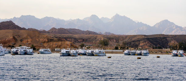 靠近多岩石海岸的游船图片下载