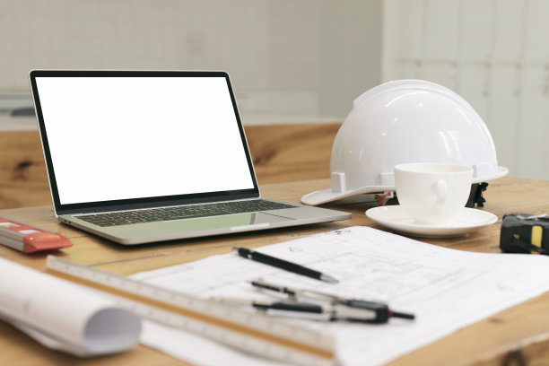 建筑平面图，笔记本电脑，屏风，铅笔，钢笔，尺子，眼镜，智能手机和蓝图在木桌上。建筑蓝图办公室办公桌背景建设项目构思概念。图片下载