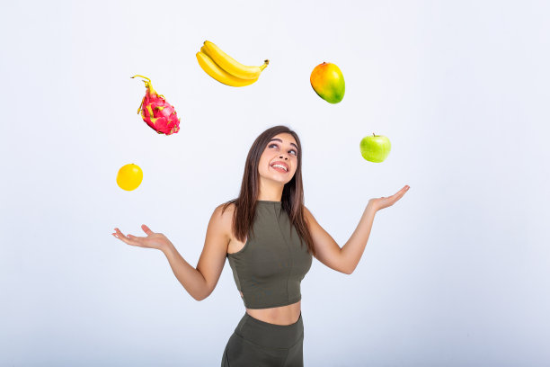 美丽，健美，拿着水果摇摆的年轻女子。健身的女人开心的微笑着拿着水果。健康生活方式照片白种人健身模型孤立在白色背景。图片下载