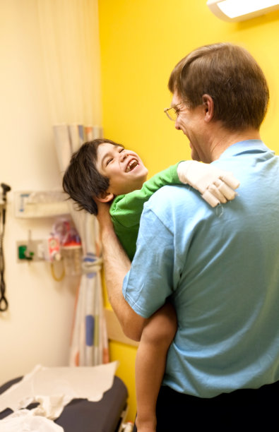 父亲在医生的病房里抱着生病的残疾小男孩图片下载