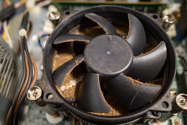 电脑内部的一个非常脏的电脑风扇用吸尘器清洁图片下载