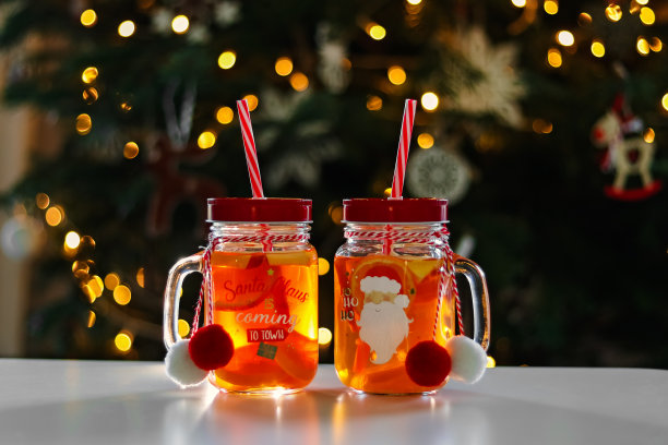 健康的圣诞冬季水果茶与桔子和苹果水果在玻璃罐与圣诞树的背景。水果时令饮料与水果块。在寒冷的季节里变暖。冬天的生活方式图片下载