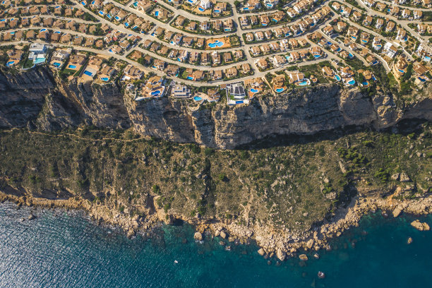 顶部鸟瞰图的蒙特卡拉村与彩色的建筑，别墅和游泳池的岩石悬崖el cim del sol，阿利坎特，西班牙图片下载