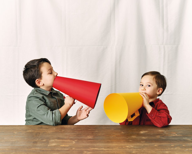 两个孩子正在用纸扩音器说话图片下载