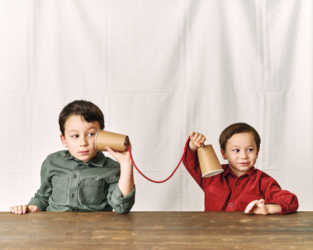 两个孩子正在用纸杯当电话。图片下载