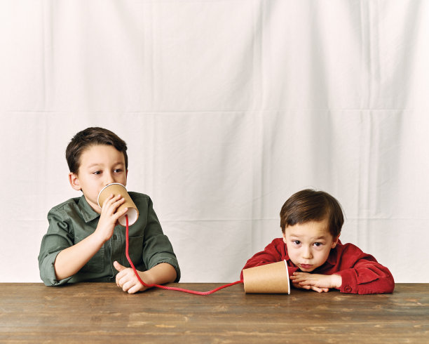 两个孩子正在用纸杯当电话。图片下载