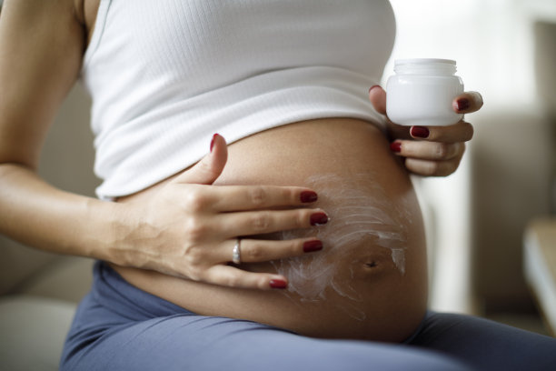 孕妇在腹部涂抹护肤霜以防止妊娠纹图片下载