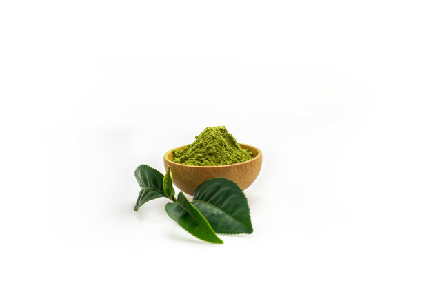 白色地板上有一堆绿茶精粉。上面放上迷你绿茶叶。图片下载