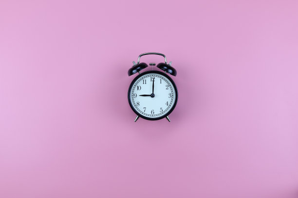 俯视图，粉色背景上的黑色闹钟，图片下载