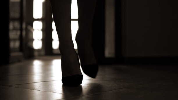 在黑暗的走廊里，跟着一个不认识的女人的脚步声，她穿着高山鞋走在过道上图片下载