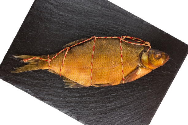 石板上的烟熏鲷鱼。布里姆在一个黑色的石板表面特写。前视图。图片下载