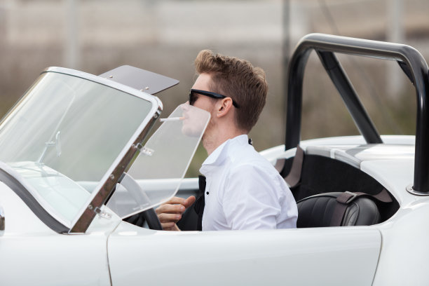 英俊的男人在一辆老爷车旁抽烟图片下载