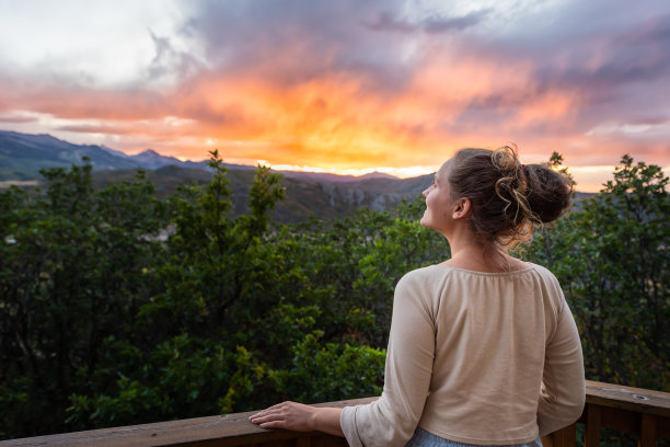 阿斯彭，科罗拉多州的落基山脉彩色日落的背景与年轻快乐的女人看的观点在黄昏图片下载