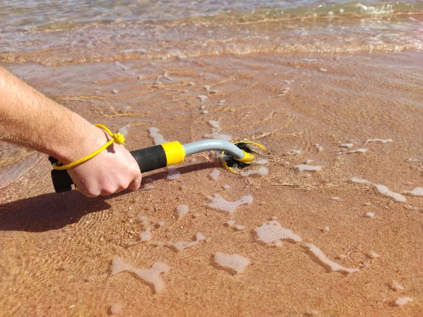 水下金属探测器和沙滩上的铲子照片：寻宝和旅游探险背景图片下载