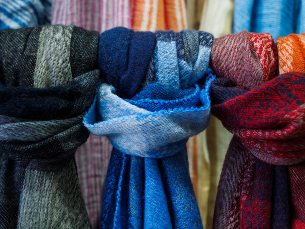 羊毛围巾挂在商店橱窗里。五颜六色的围巾打结图片下载