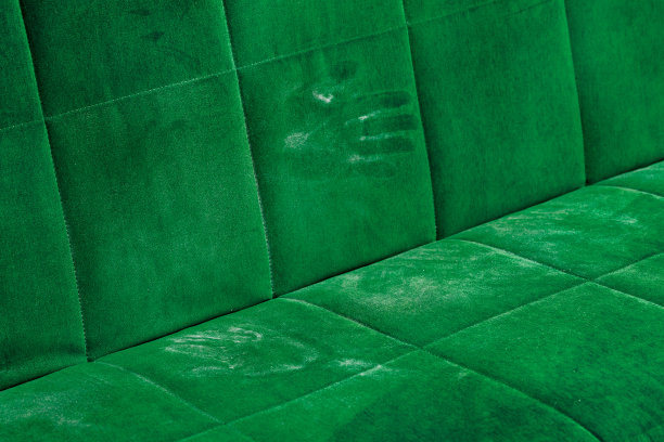 灰尘绿色沙发表面与掌纹特写与选择性焦点图片下载