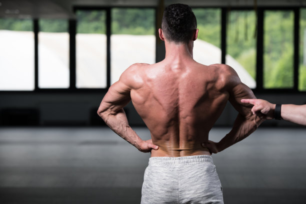 英俊的肌肉男在健身房展示肌肉图片下载