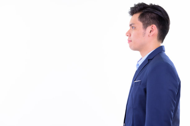 侧面的年轻英俊的亚洲商人在西装图片下载