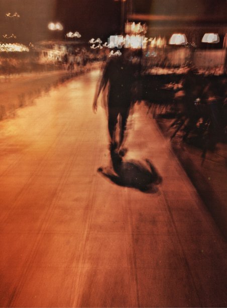 一个男人在晚上走在街上的模糊运动视图图片下载