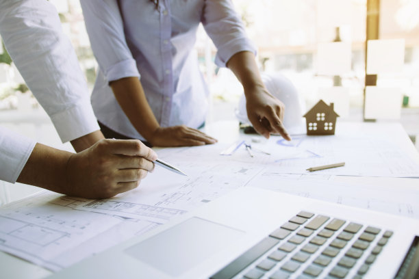 两名建筑师工作在建筑工地和指南针指向蓝图的伙伴关系。图片下载