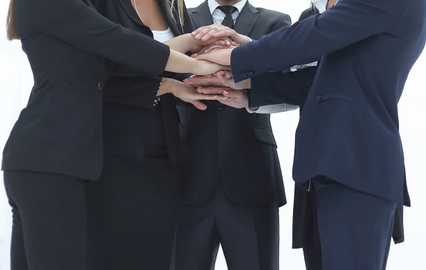 关闭了。商人和朋友们一叠手，展示团结和团队精神图片下载