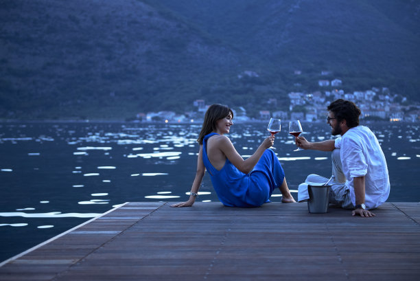 日落时分，一对年轻夫妇在海边庆祝结婚纪念日素材图片