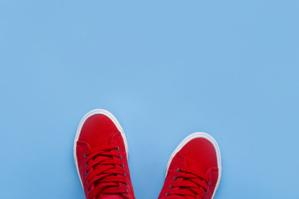 蓝色背景上的红色运动鞋。极简主义风格。平坦的躺,t图片下载