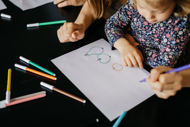 一个孩子的手和他的绘画和着色与马克笔的特写图片下载